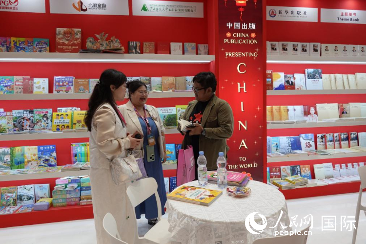 中国出版展区工作人员向印尼读者介绍中国图书。人民网记者 曹师韵摄